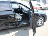 a black car with its door open in a parking lot