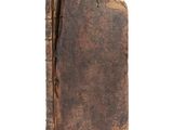 an old book with a brown cover sitting on top of a white surface