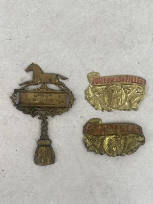 three metal badges are sitting on a white surface