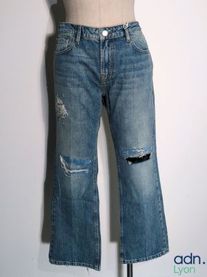 jeans on a mannequin stand on a white wall