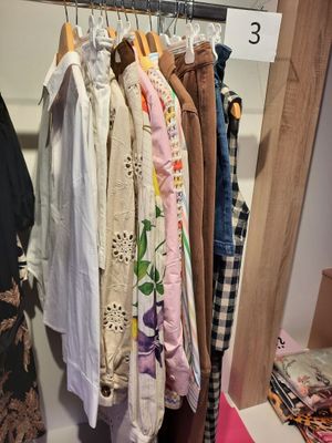 beaucoup de vêtements suspendus à un portant dans un placard