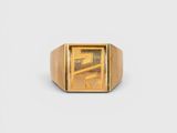a close up of a gold signet ring on a white background