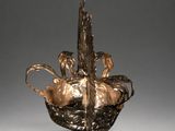 an image of a bronze sculpture of a bird in a basket