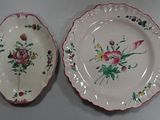 two plates with flowers on them sitting on a table