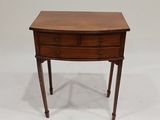 une petite table en bois avec deux tiroirs d'un côté et un tiroir de l'autre côté