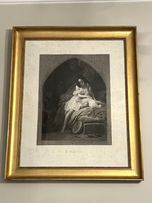 une photo d'une femme assise sur un lit, dans un cadre doré
