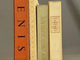 trois livres sont empilés sur une table