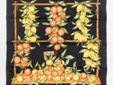 un gros plan sur un foulard carré noir orné d'oranges et de feuilles