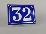 une photo d'une plaque de numéro de maison bleue et blanche fixée sur un support métallique