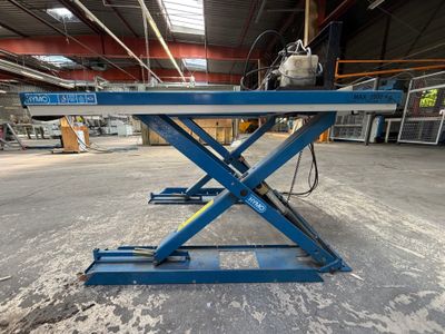 un gros plan sur une paire de ciseaux bleus dans un entrepôt