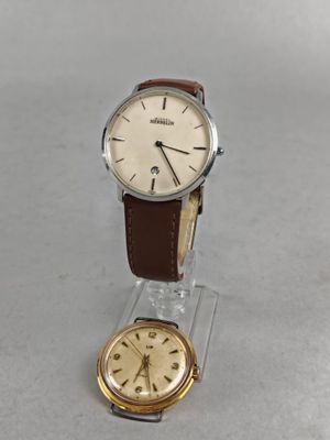une image représentant une montre et un présentoir à montre posés sur une table