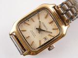 a close up of a gold watch on a white surface