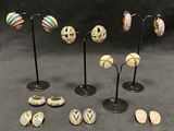 five pairs of earrings that are sitting on a stand