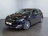 La voiture noire est garée dans une grande pièce au sol noir.
