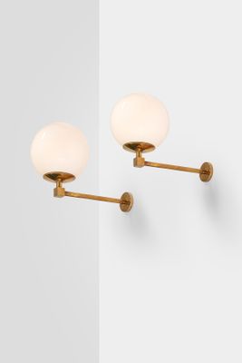 a pair of brass wall lights on a white wall