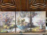 trois tableaux représentant des fleurs dans un vase posé sur une étagère devant une armoire en bois