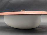 a close up of a white bowl with a wooden lid