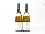 deux bouteilles de vin posées l'une à côté de l'autre sur une surface blanche
