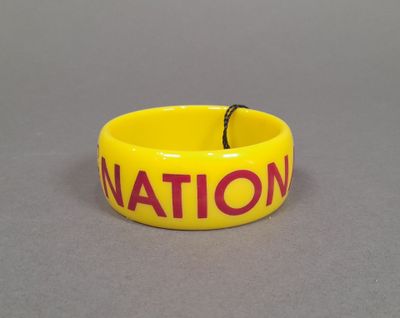 COSTUME NATIONAL. Bracelet en plastique jaune à inscription …