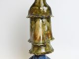 a ceramic sculpture of a man with a hat on top of it