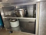 many pots and pans on the shelf in the kitchen