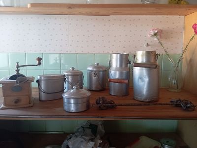 de nombreuses casseroles et poêles sur une étagère dans la cuisine