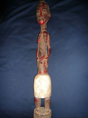une vieille statue en bois d'un homme avec un chapeau sur la tête