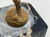 bronze statue of a man holding a baseball bat on top of a marble base