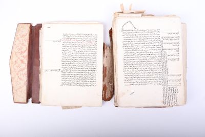 an open book with arabic writing on it sitting on top of a white surface