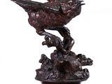 sculpture en bronze représentant un oiseau perché sur une branche d'arbre, posée sur un socle