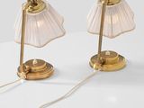 pair of brass table lamps with pleated lampshads on a white surface
