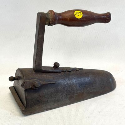 an old iron with a wooden handle on a white surface
