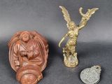 two small figurines of angels and a coin on a table