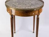 une table ronde avec un plateau en marbre et des pieds en bois