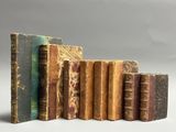plusieurs vieux livres sont alignés sur une surface blanche