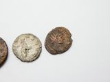 trois pièces anciennes posées les unes à côté des autres sur une table