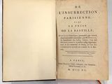 un livre ouvert posé sur une table, à côté d'une étiquette