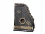 un vieil instrument de musique noir et doré sur fond blanc
