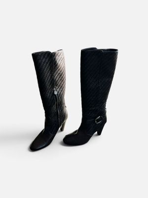 deux paires de bottes noires et blanches posées sur une surface blanche