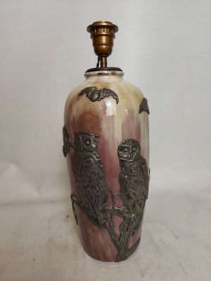 un grand vase orné de deux oiseaux, posé sur une table