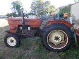 un tracteur rouge garé dans l'herbe