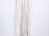 the white dress is hanging on a hanger on a white wall