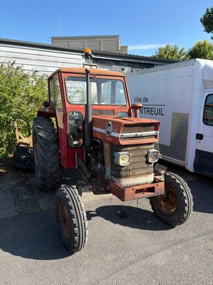 a red tractor that is parked next to a white truck