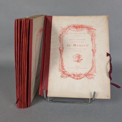 an old book with a red cover sitting on top of a metal stand