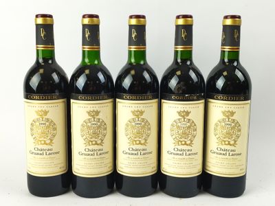 quatre bouteilles de vin sont alignées sur une surface blanche