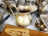 de nombreuses théières en argent et d'autres objets en argent posés sur une table