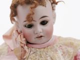 a close up of a doll wearing a pink dress