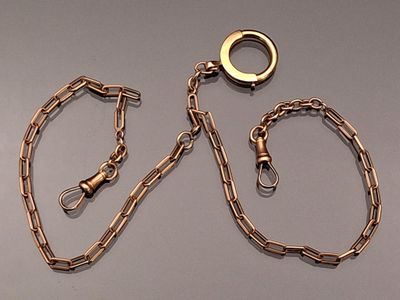 a gold chain with a ring on it and a chain with a ring on it