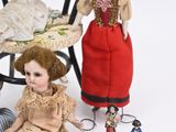 a lot of dolls that are sitting on a chair