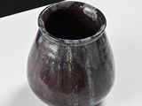 a brown vase sitting on a white table